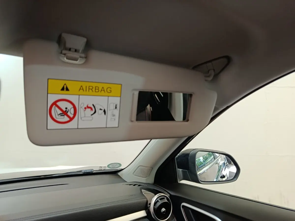 Vue intérieure côté passager du MG ZS Luxury 70kWh 2024, montrant le pare-soleil avec miroir et rétroviseur noir.