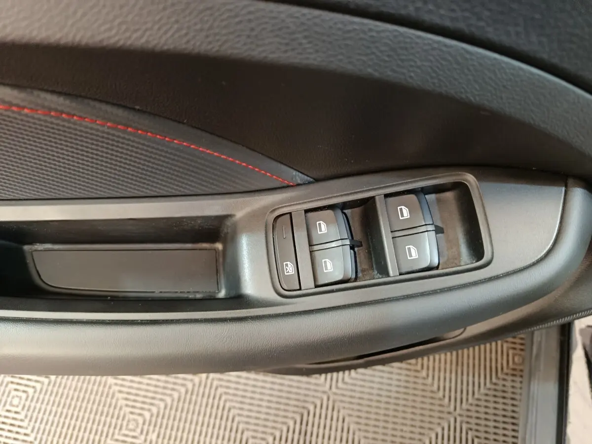 Vue rapprochée des commandes de lève-vitres sur la porte côté gauche d’un MG Motor ZS noir 2024.