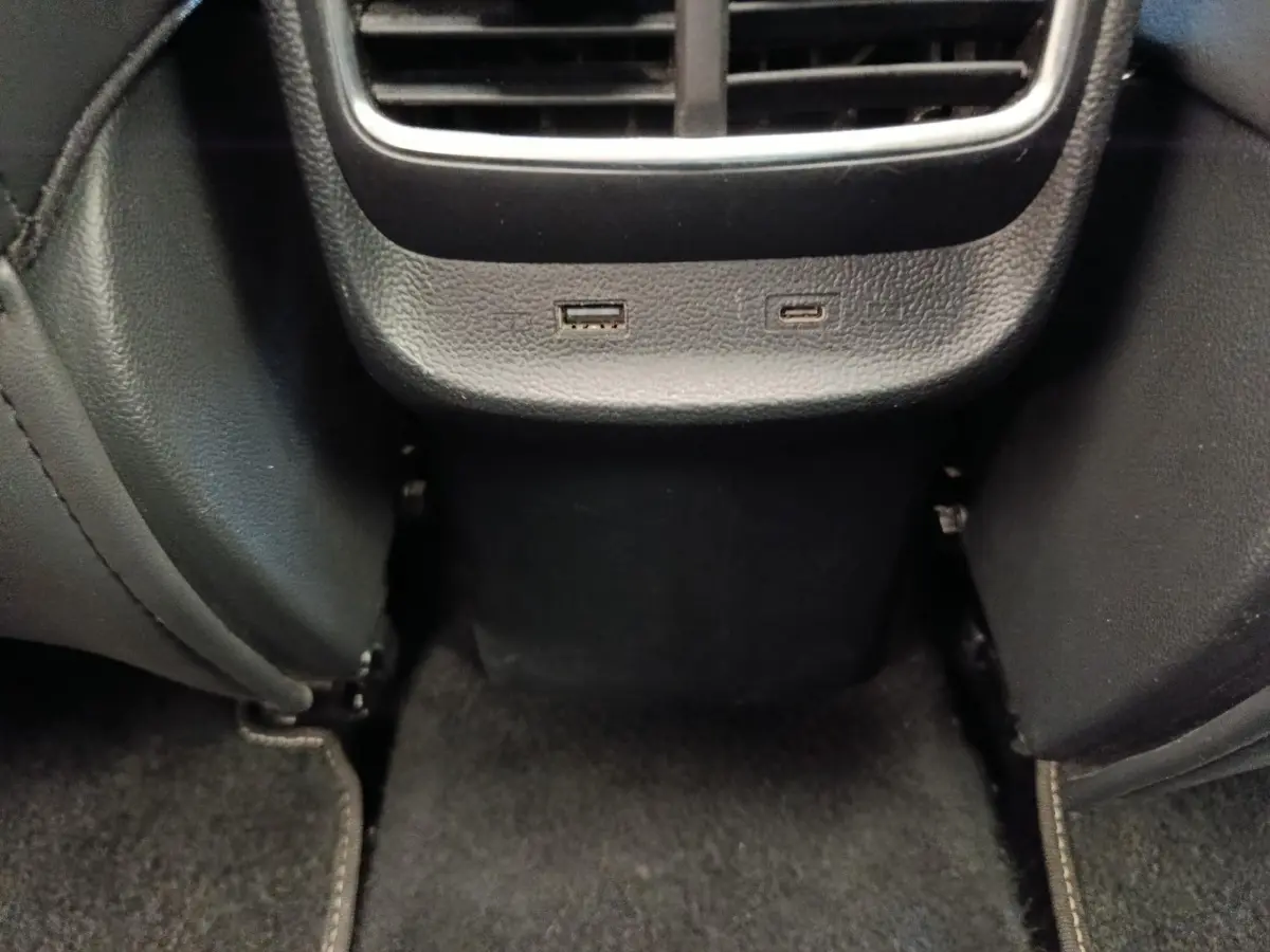 Vue rapprochée de la console arrière noire du MG ZS Luxury 2024 avec prises USB et aérateurs visibles.