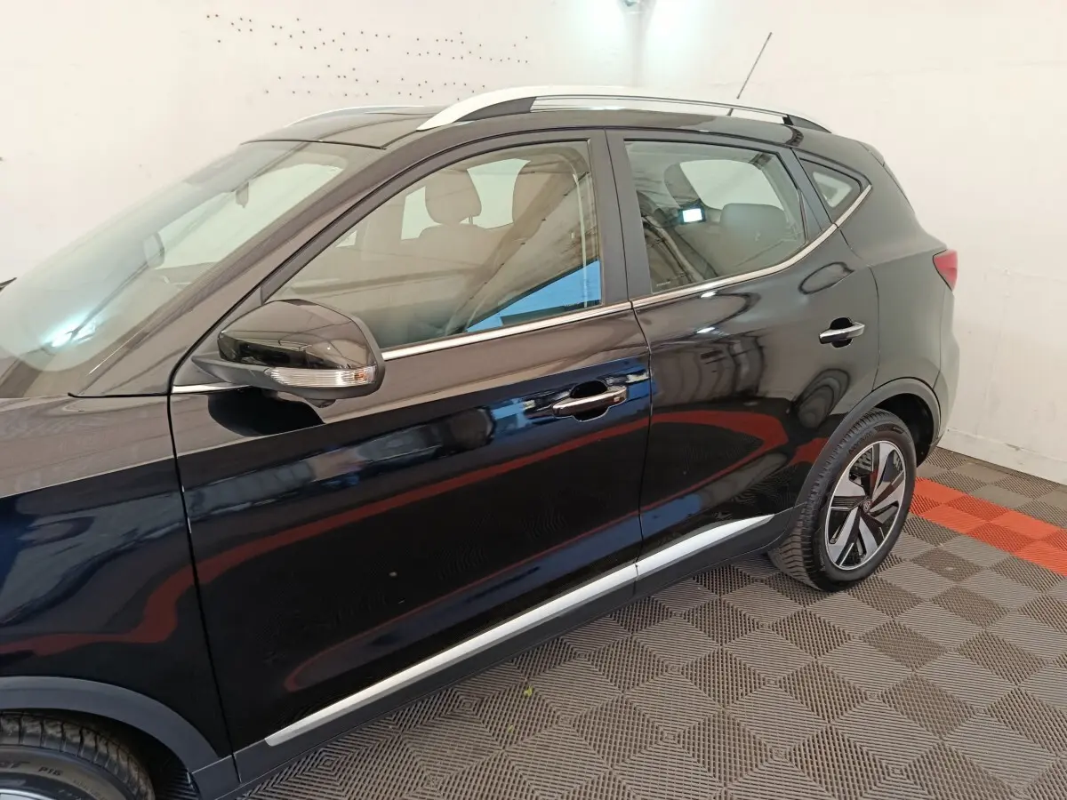 Vue latérale côté gauche du MG MOTOR ZS Luxury 70kWh noir, mettant en valeur les jantes et les rétroviseurs avec clignotants intégrés.
