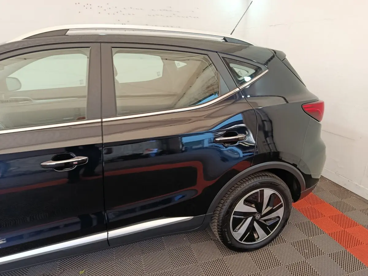 Vue latérale côté droit du MG ZS Luxury 70kWh noir, mettant en valeur les jantes et la ligne de toit chromée.