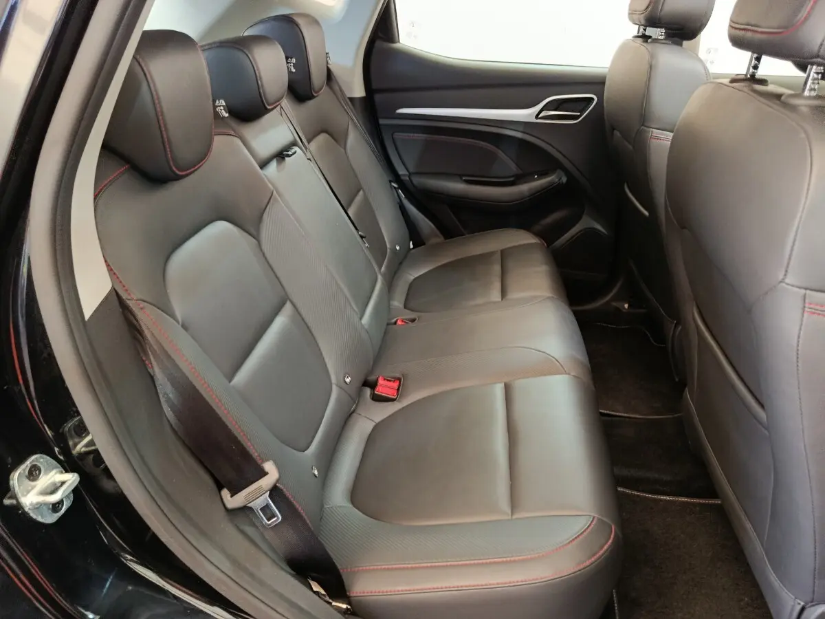 Vue intérieure côté gauche des sièges arrière en cuir noir avec surpiqûres rouges du MG MOTOR ZS Luxury 2024.