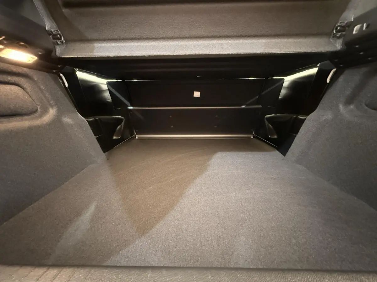 Vue intérieure du coffre spacieux et bien éclairé de la Peugeot 208 blanche 2025, version Active Business.