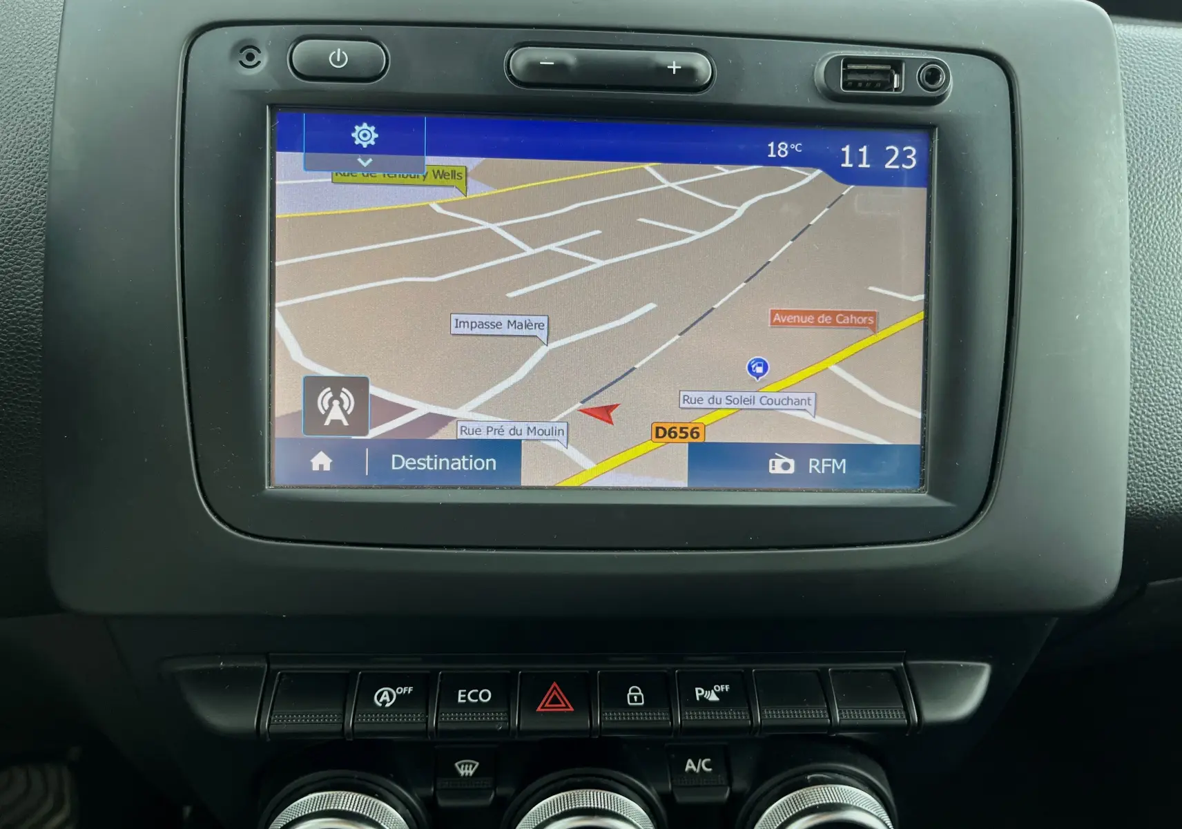 Écran tactile GPS du tableau de bord du Dacia Duster bleu marine 2018, avec commandes climatisation et mode ECO visibles.