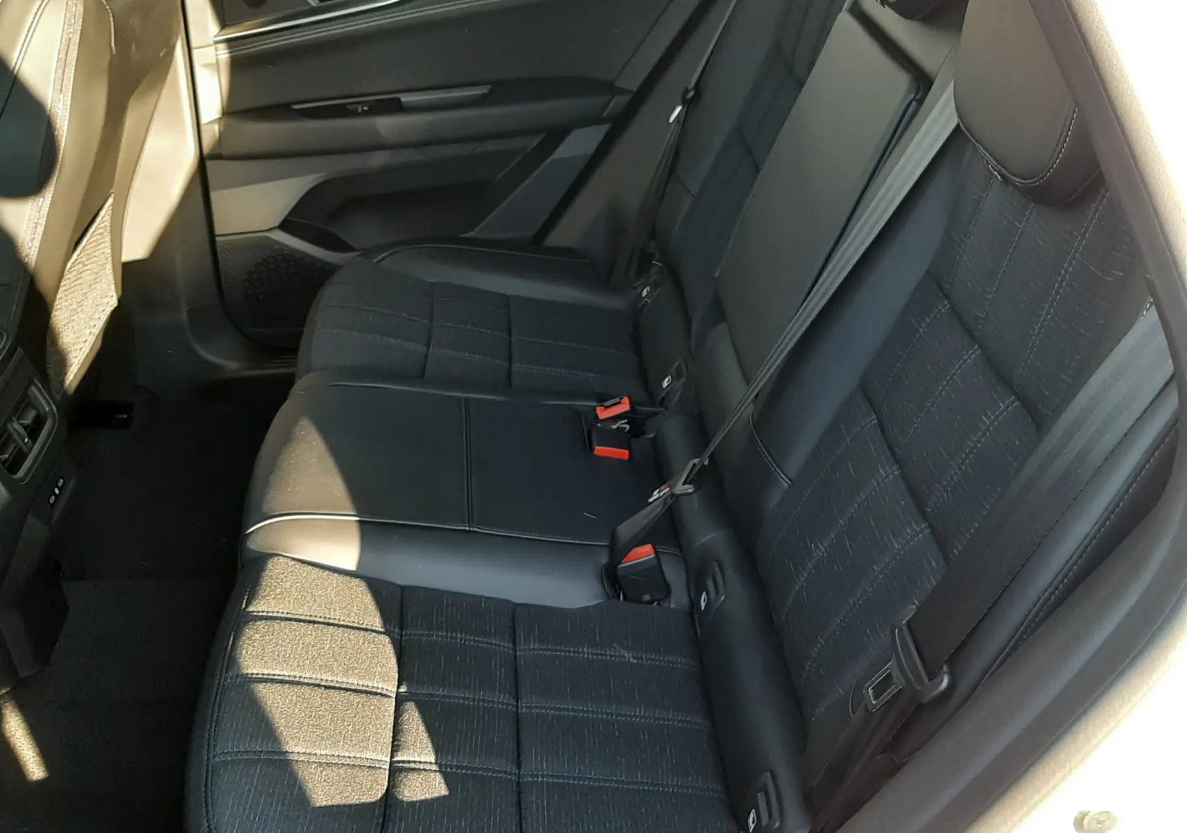 Vue intérieure côté droit des sièges arrière en tissu noir avec surpiqûres blanches du Renault Austral 2025 blanc nacré.