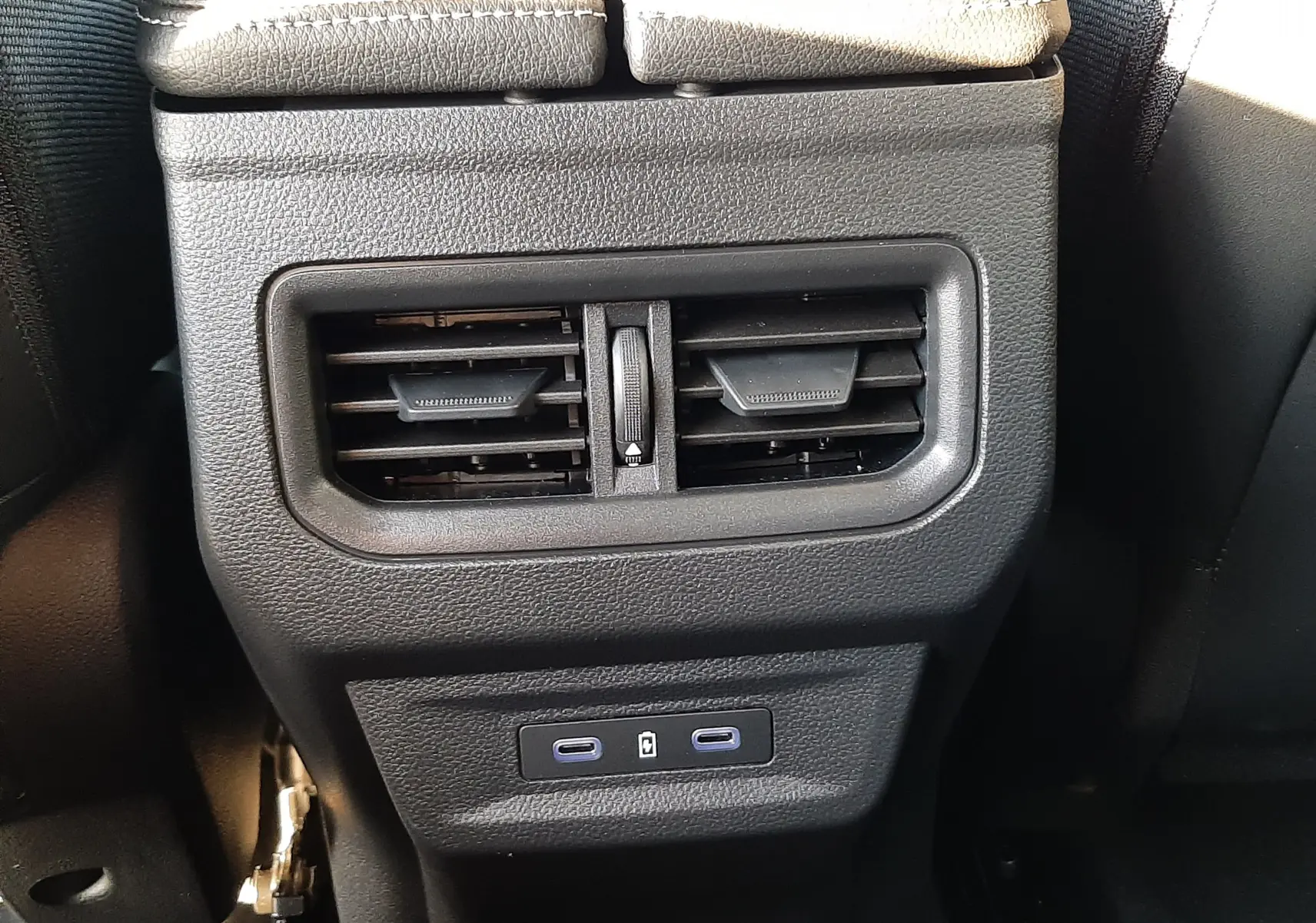 Détail de la console centrale arrière noire du Renault Austral 2025 avec bouches d'aération et ports USB-C visibles.