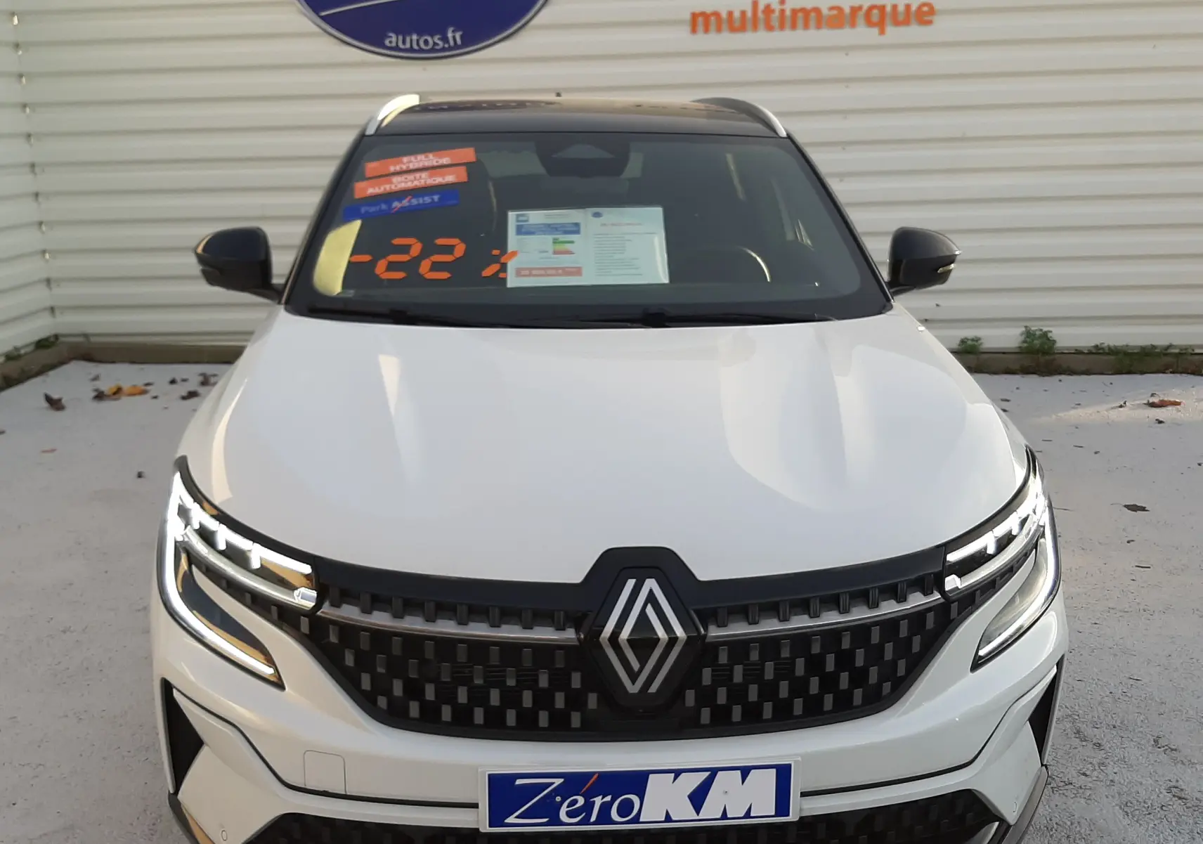 Vue de face du Renault Austral E-Tech Full Hybrid 200 Iconic blanc nacré avec toit noir et calandre noire distinctive.