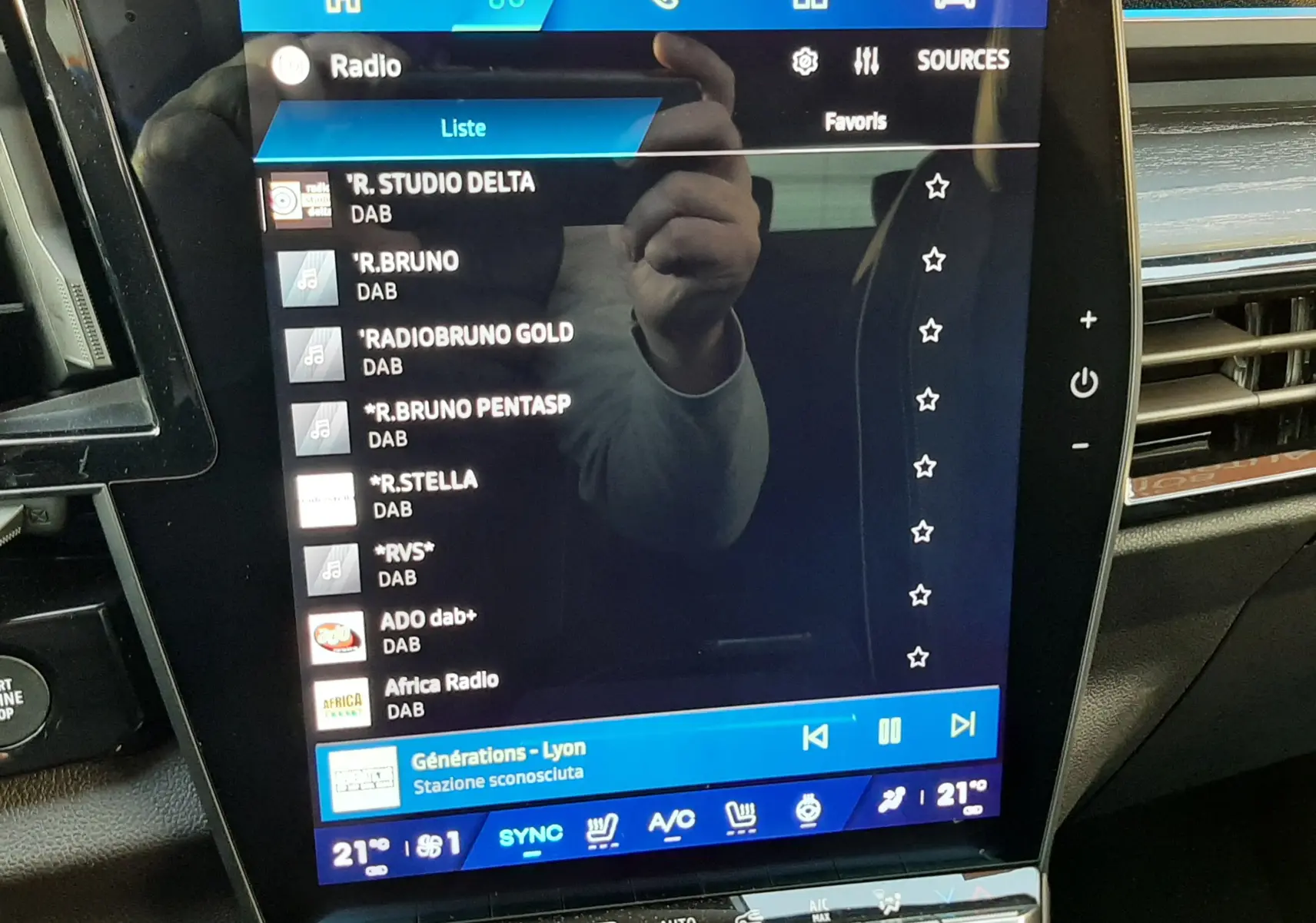 Écran tactile central du Renault Austral E-Tech blanc nacré, affichant la liste des radios DAB avec commandes climatisation en dessous.