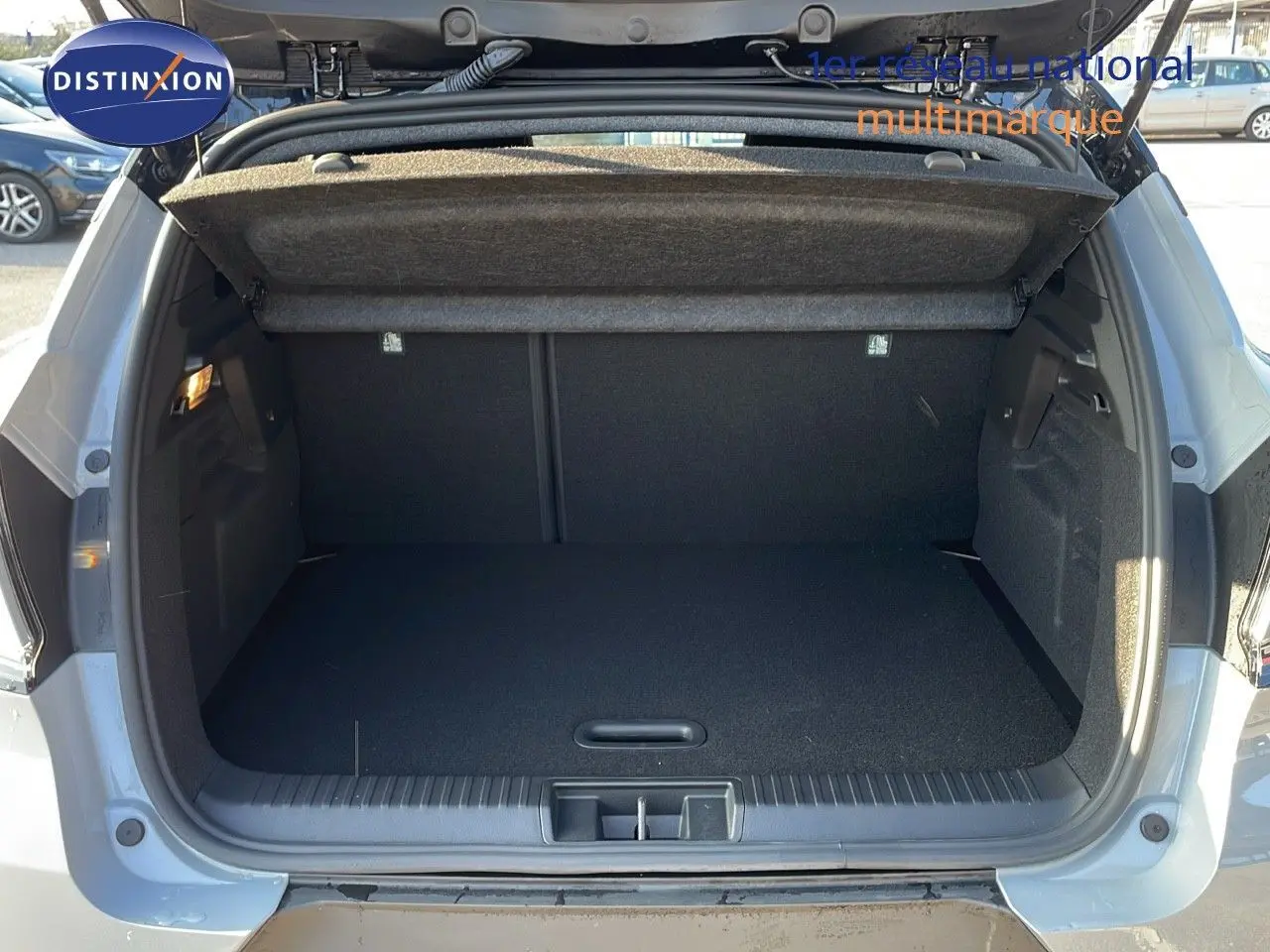 Coffre ouvert d'un Renault Captur E-Tech gris Rafale métal avec toit noir, vue arrière montrant l'espace de chargement vide.