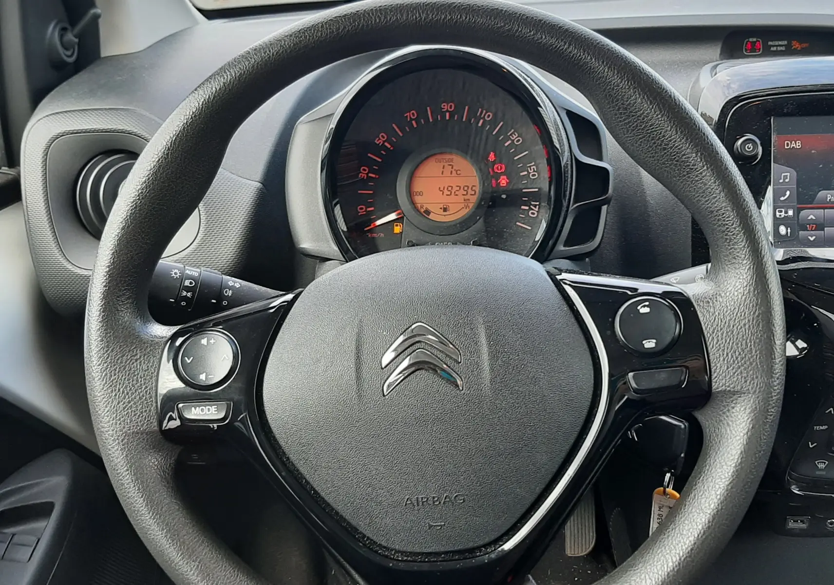 Vue rapprochée du volant noir de la Citroën C1 2021 avec tableau de bord et compteur digital affichant 49295 km.