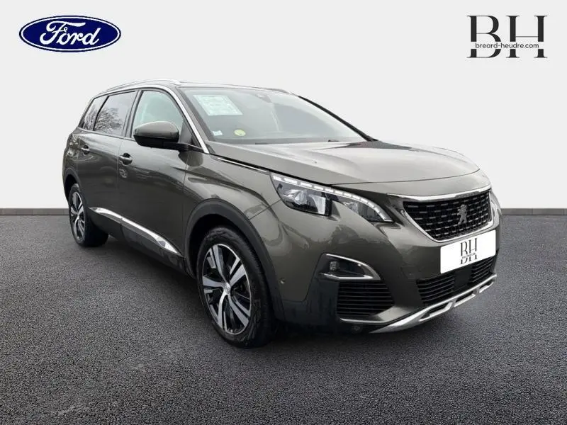 Peugeot 5008 gris Amazonite vue 3/4 avant droit, avec jantes alu et projecteurs Full LED visibles.