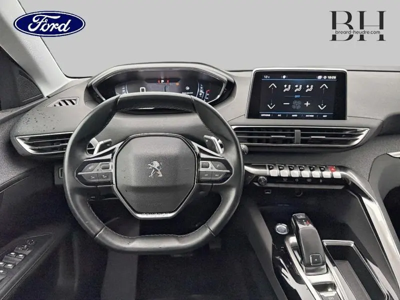 Vue intérieure centrée sur le volant cuir et le tableau de bord numérique du Peugeot 5008 gris Amazonite.