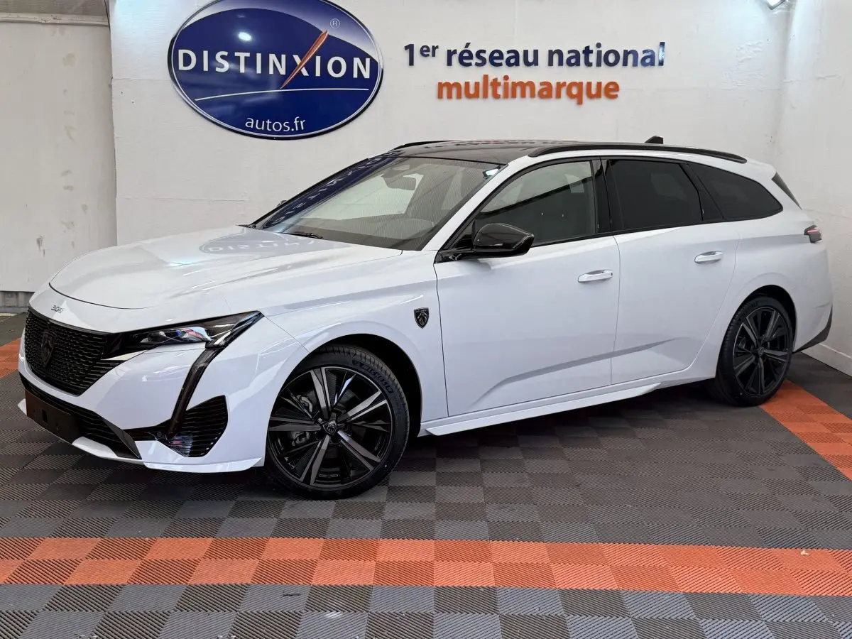 Peugeot 308 Hybrid 136 e-DCS6 GT blanche vue 3/4 avant droit, jantes noires et toit noir contrasté.