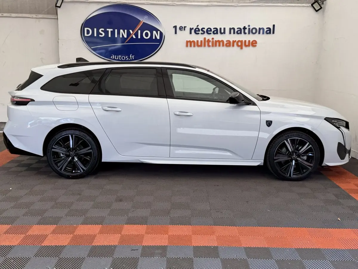 Peugeot 308 Hybrid 136 e-DCS6 GT blanc vue de profil côté gauche, jantes noires et toit ouvrant panoramique.