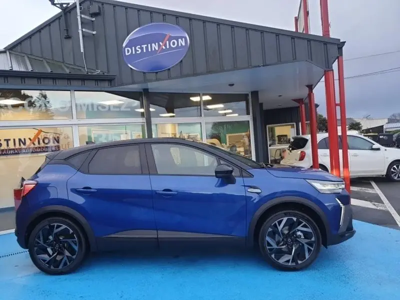 Vue latérale droite du Renault Captur 1.6 E-Tech full hybrid 2025 en Bleu Iron, avec jantes alu et toit noir contrasté.