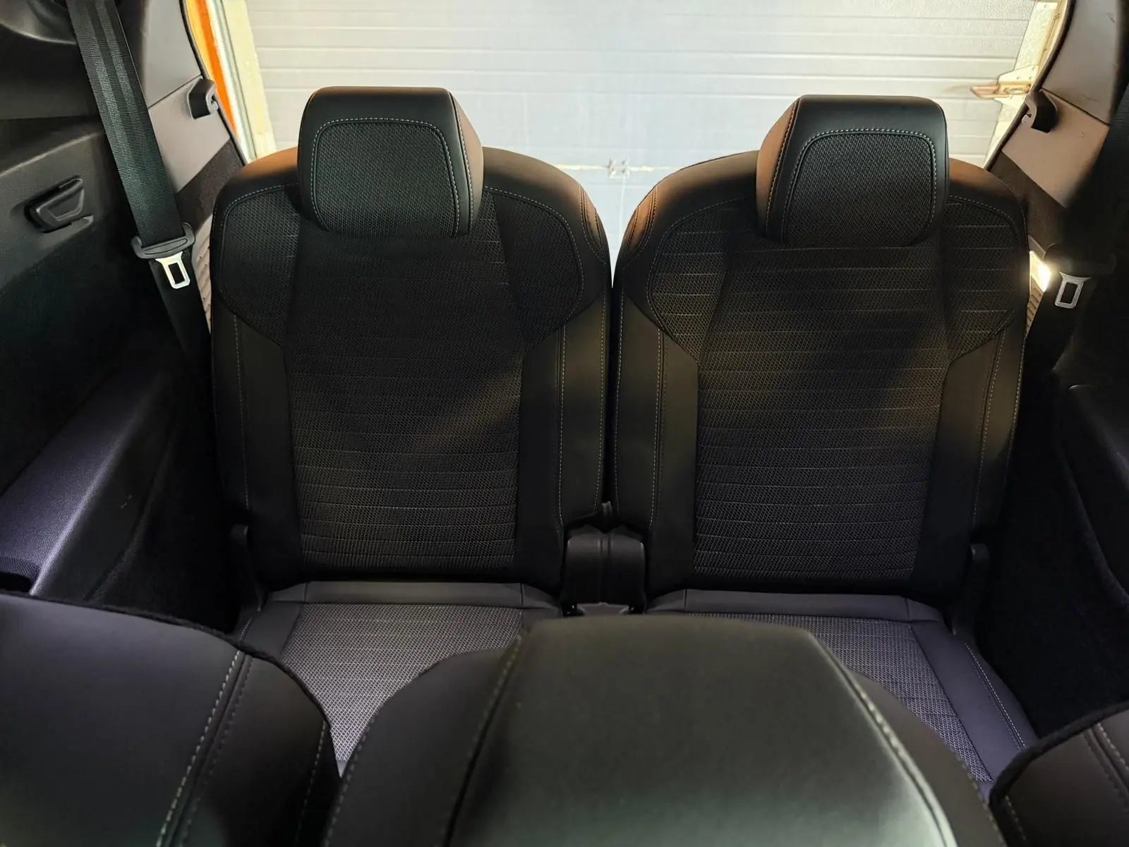Vue arrière centrée sur les deux sièges noirs du troisième rang du Peugeot 5008 Hybrid 145 GT, avec ceinture visible.
