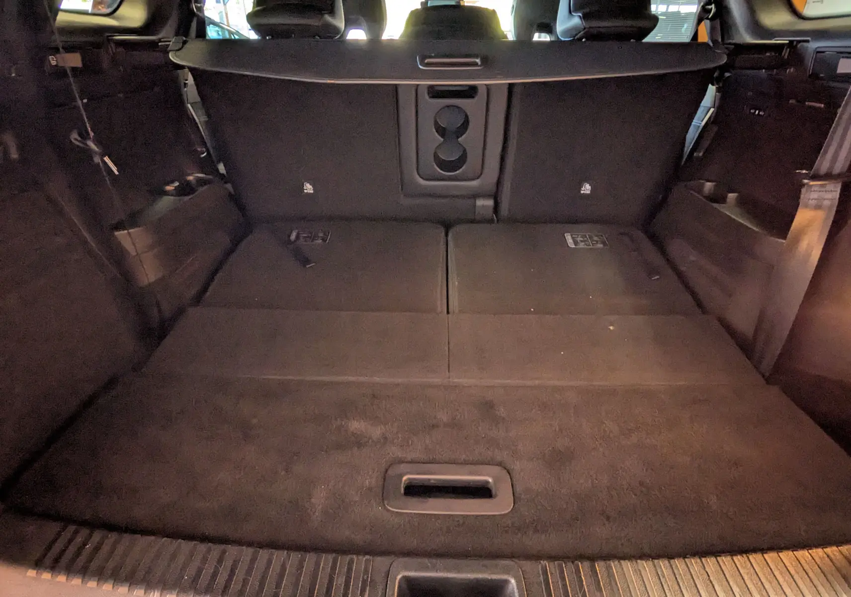 Coffre noir étoile du Renault Espace VI E-Tech, vue intérieure arrière avec sièges rabattus et espace de chargement plat.