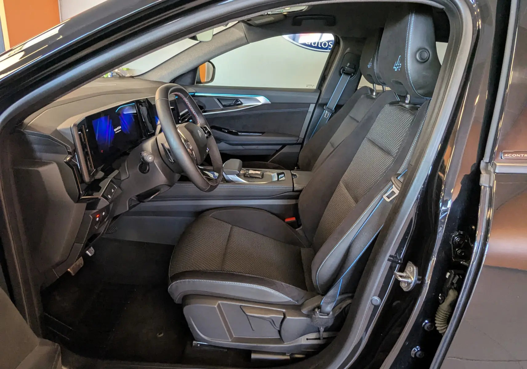 Vue intérieure côté conducteur du Renault Espace VI noir étoile, sièges tissu/Alcantara avec logo Alpine sur appui-tête.