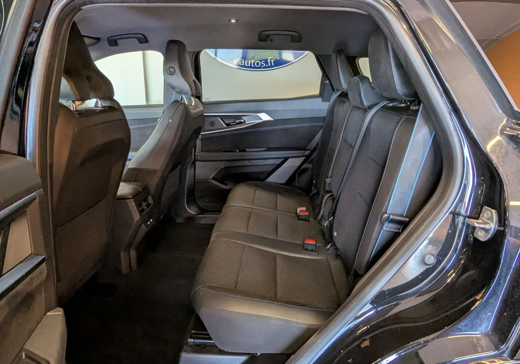 Vue intérieure côté droit des sièges arrière noirs avec surpiqûres bleues du Renault Espace VI E-Tech Full Hybrid 2025.
