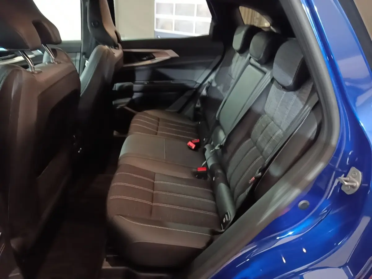 Vue intérieure côté droit sur la banquette arrière noire du Renault Austral bleu 2024, montrant les sièges et la portière ouverte.