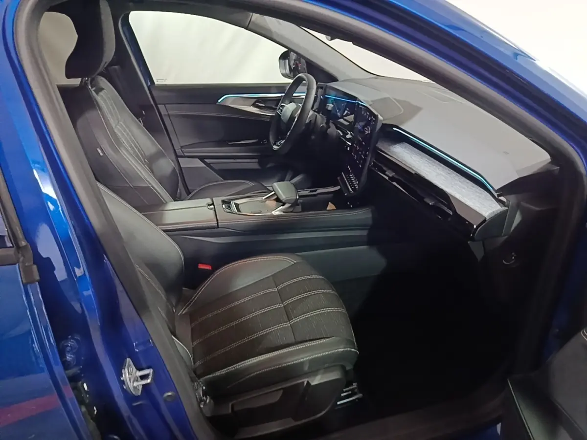 Intérieur du Renault Austral bleu 2024, vue côté conducteur, sièges cuir noirs et tableau de bord digital moderne.