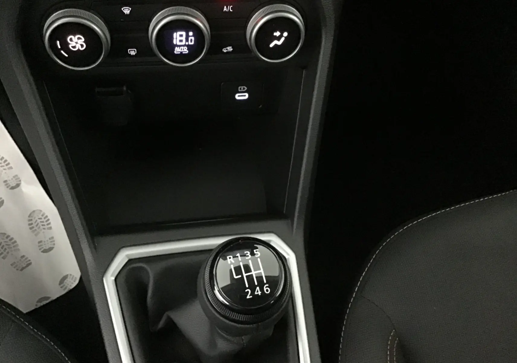Gros plan sur la console centrale de la Dacia Sandero Stepway 2025, montrant la boîte manuelle et les commandes de climatisation.