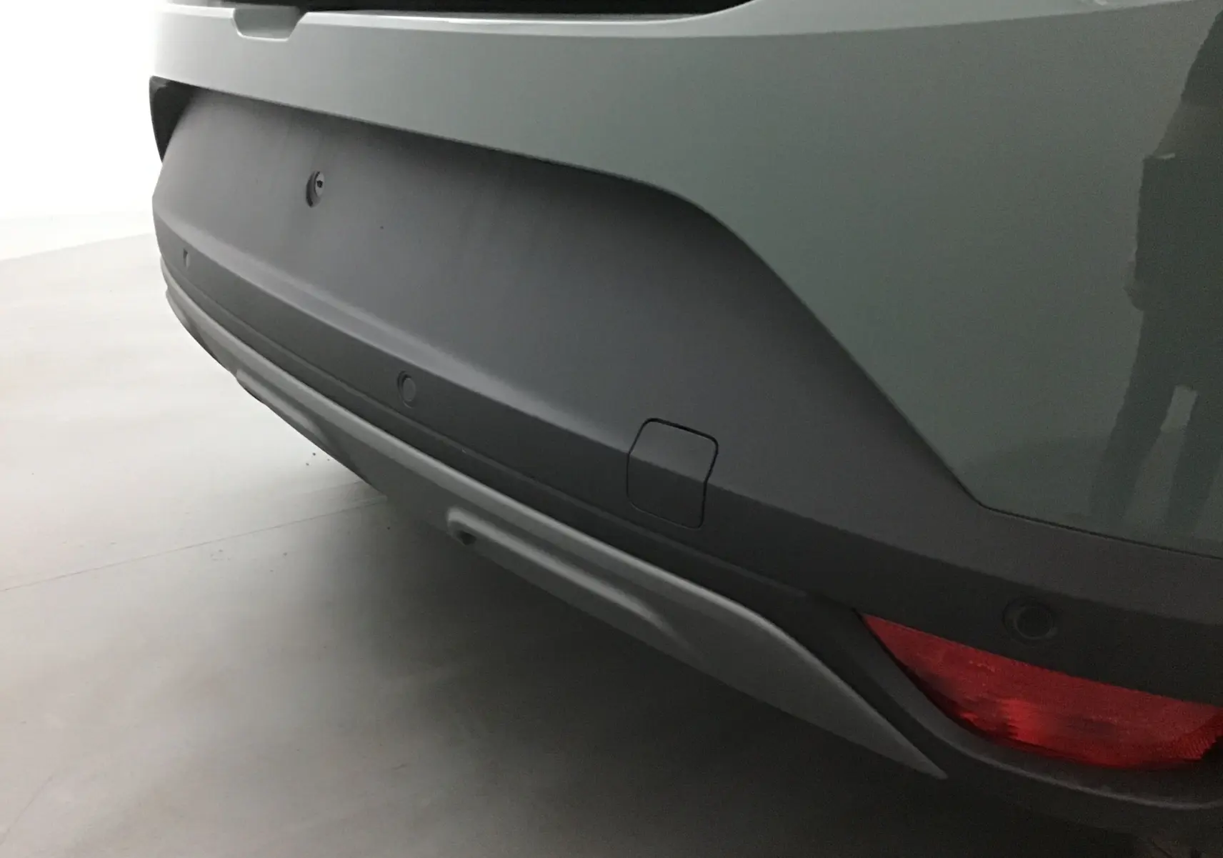 Gros plan sur le pare-chocs arrière kaki du Dacia Sandero Stepway 2025, avec feu rouge et capteurs de recul visibles.