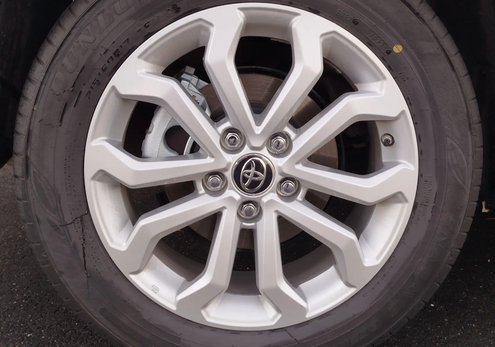 Gros plan sur la jante alliage argentée de la Toyota Corolla Cross 2025, avec logo Toyota au centre et pneu Dunlop.