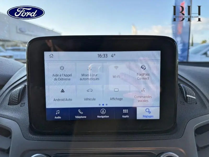 Écran tactile central du Ford Transit Connect blanc glacier, affichant le menu des réglages et connectivités.