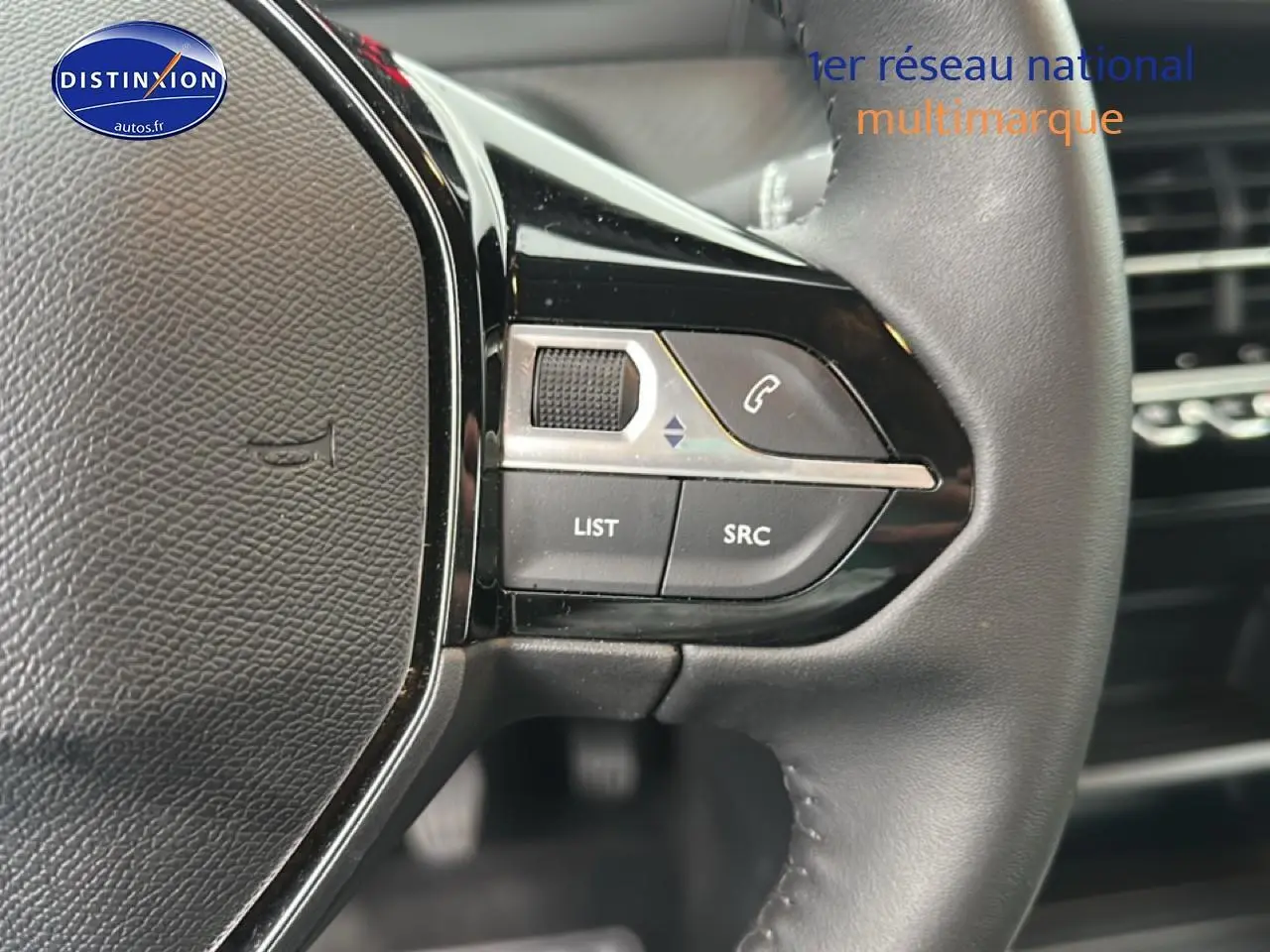 Gros plan sur les commandes au volant noir du Peugeot 208 1.2 PureTech 100 Active 2024, côté gauche.