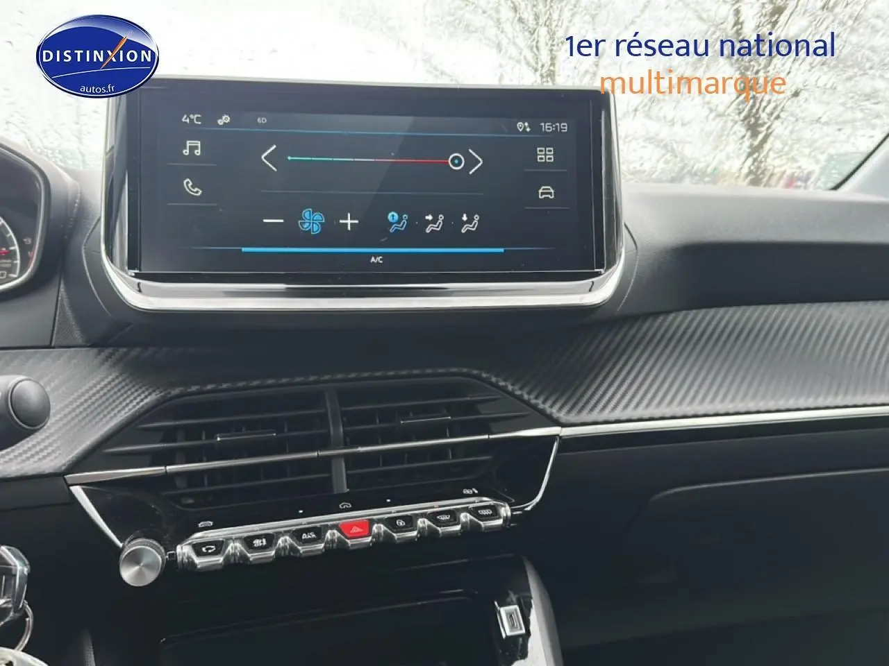 Tableau de bord de Peugeot 208 2024 gris artense, vue centrée sur l'écran tactile et les commandes de climatisation.