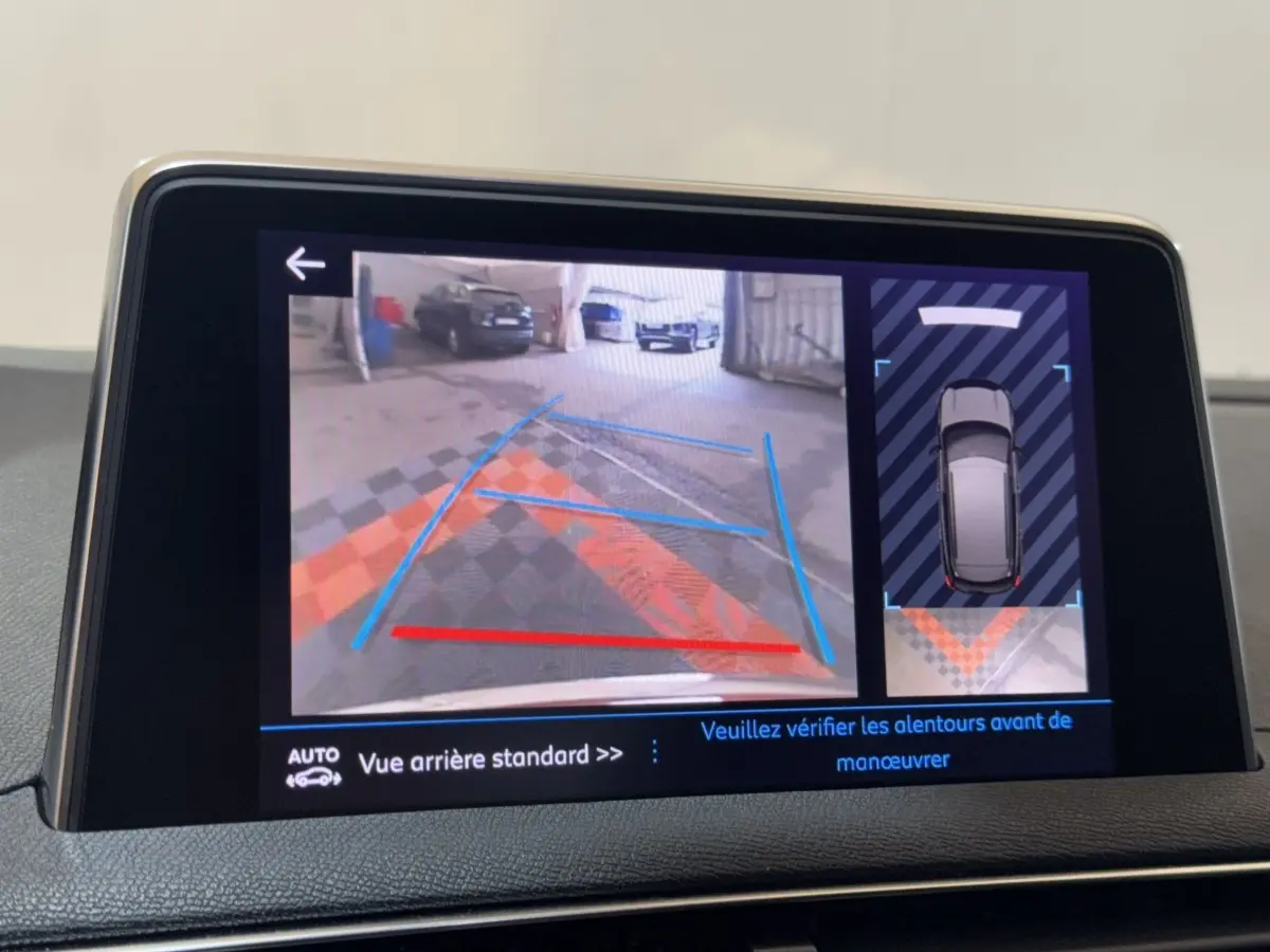 Écran tactile du système de navigation montrant la caméra de recul et l’aide au stationnement du Peugeot 3008 orange.