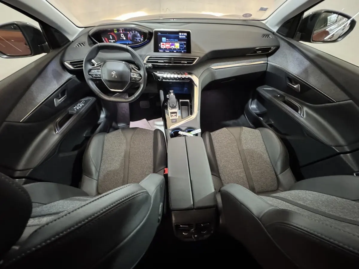 Intérieur noir et gris du Peugeot 3008 PureTech 130, vue avant centrée sur le tableau de bord et le volant compact.