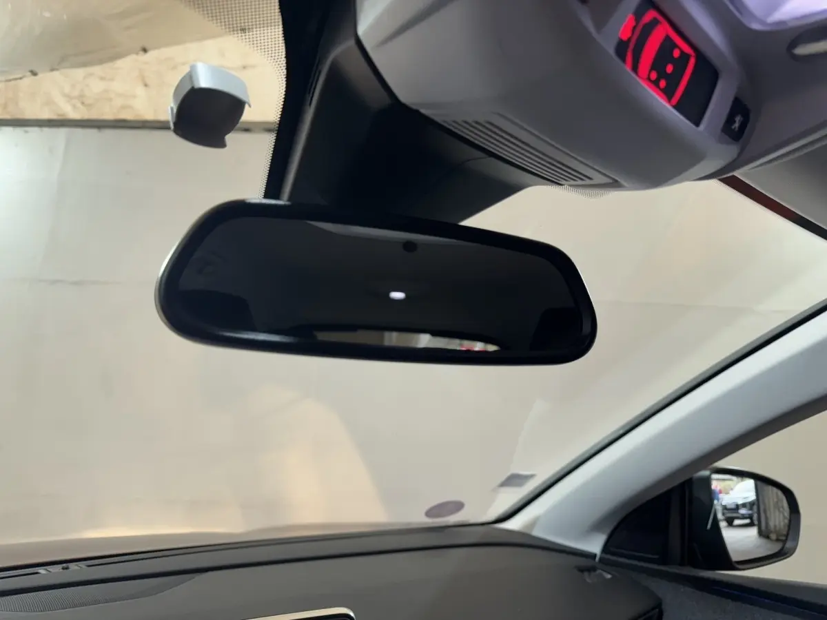 Vue intérieure du rétroviseur central et du tableau de bord côté droit du Peugeot 3008 orange 2020.