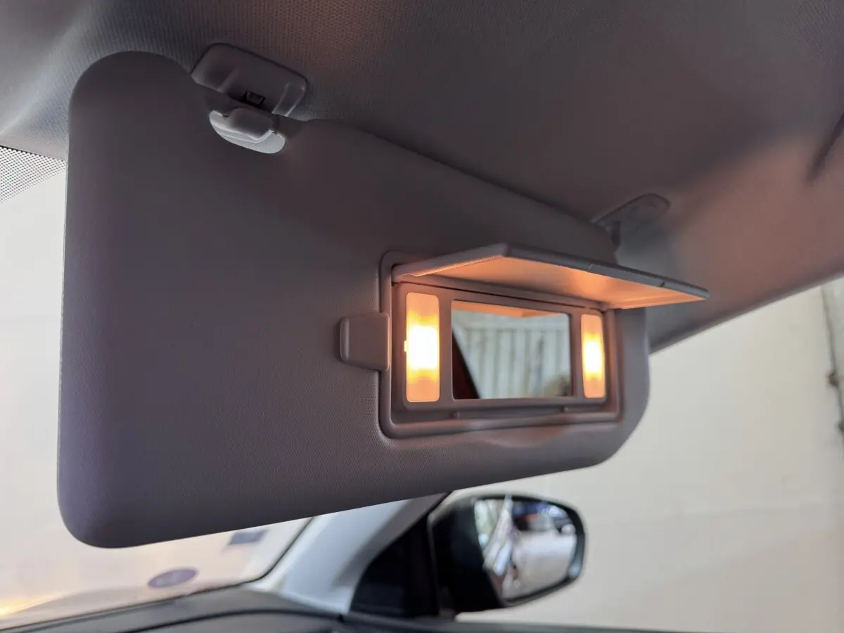 Détail de la visière côté conducteur du Peugeot 3008 orange 2020 avec miroir éclairé et rétroviseur latéral visible.