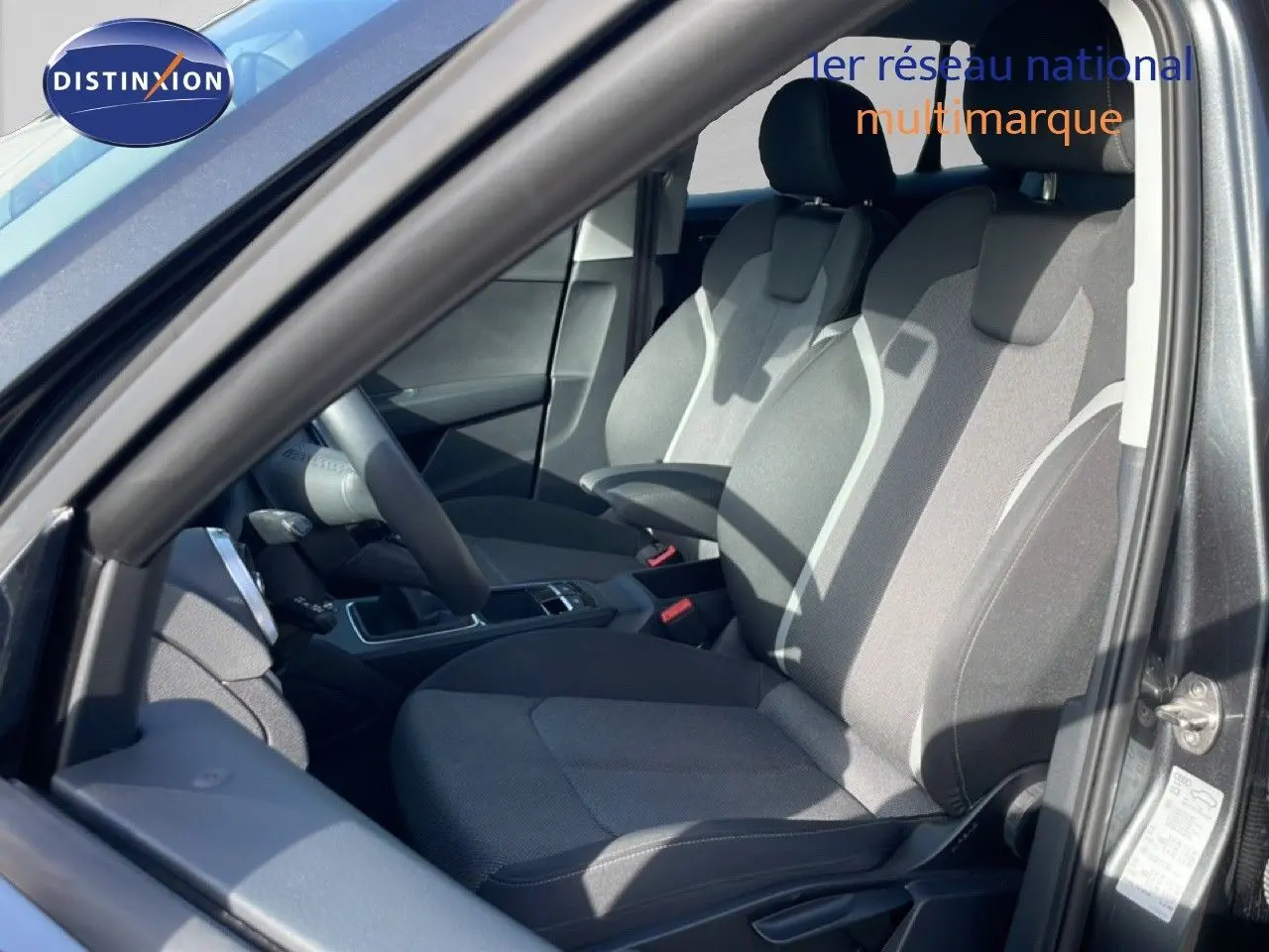 Vue intérieure côté conducteur de l'Audi Q2 30 TDI S-Line 2025, montrant les sièges tissu gris et la console centrale.