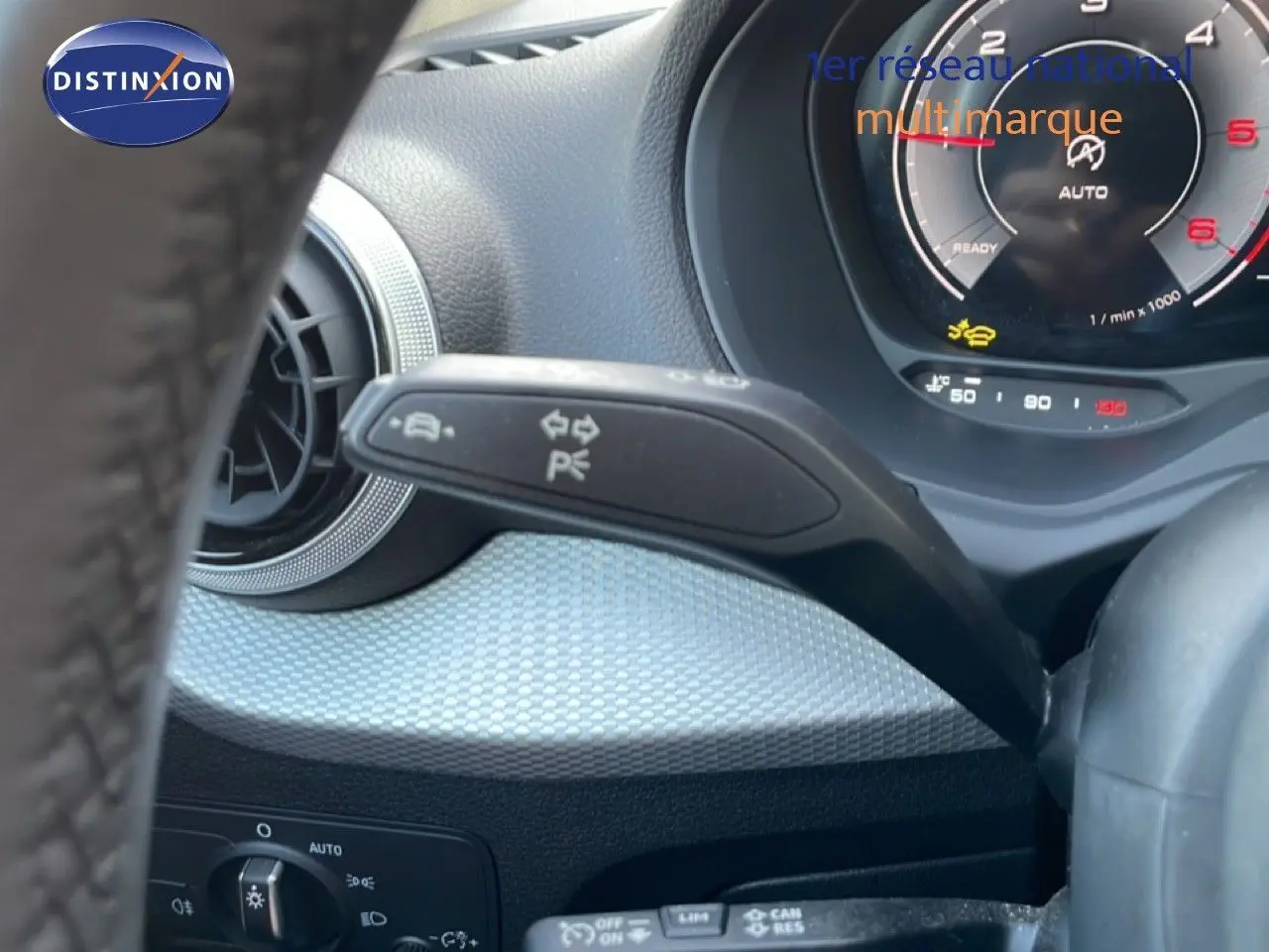 Gros plan sur le combiné d'instruments et la commande de clignotants d'un Audi Q2 gris Manhattan, intérieur noir.