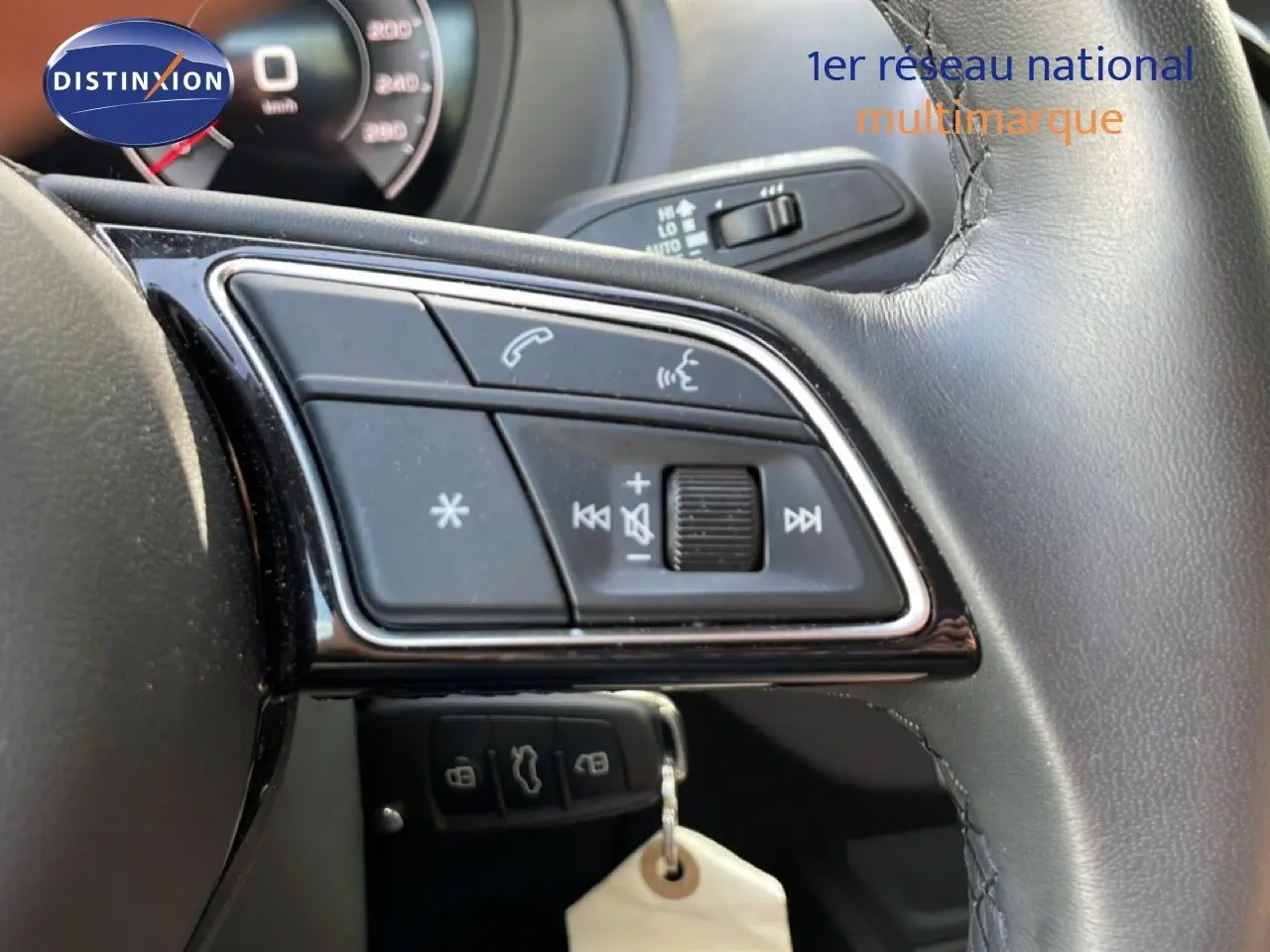 Gros plan sur les commandes du volant en cuir noir de l'Audi Q2 gris Manhattan 30 TDI S-Line 2025.