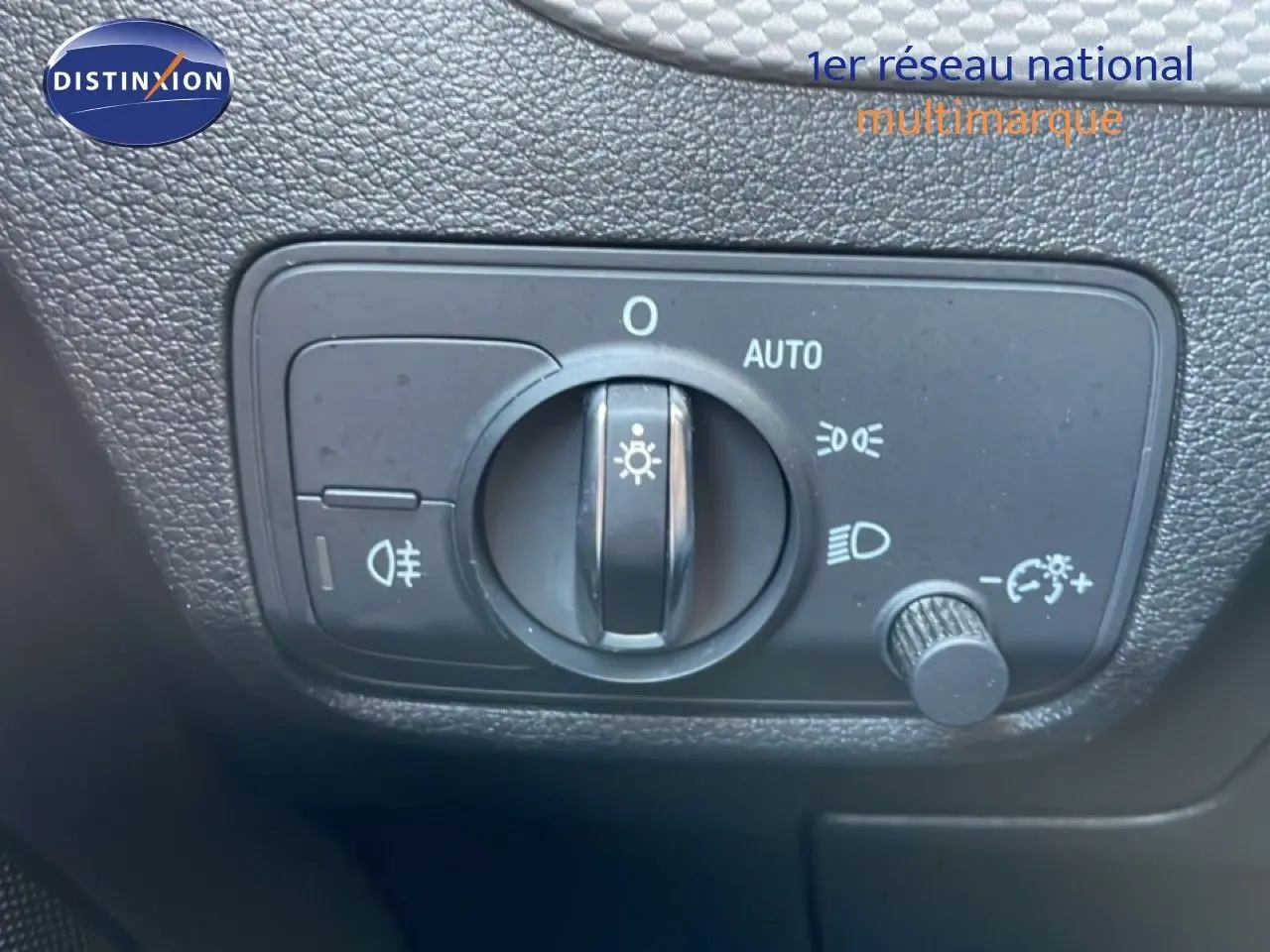 Gros plan sur le bouton de commande des phares dans l’habitacle de l’Audi Q2 gris Manhattan 30 TDI S-Line 2025.