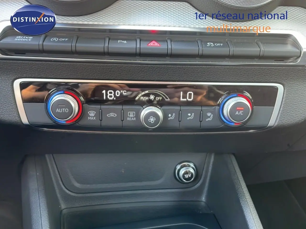 Vue rapprochée de la console centrale de l’Audi Q2 30 TDI S-Line 2025, montrant les commandes de climatisation digitale.