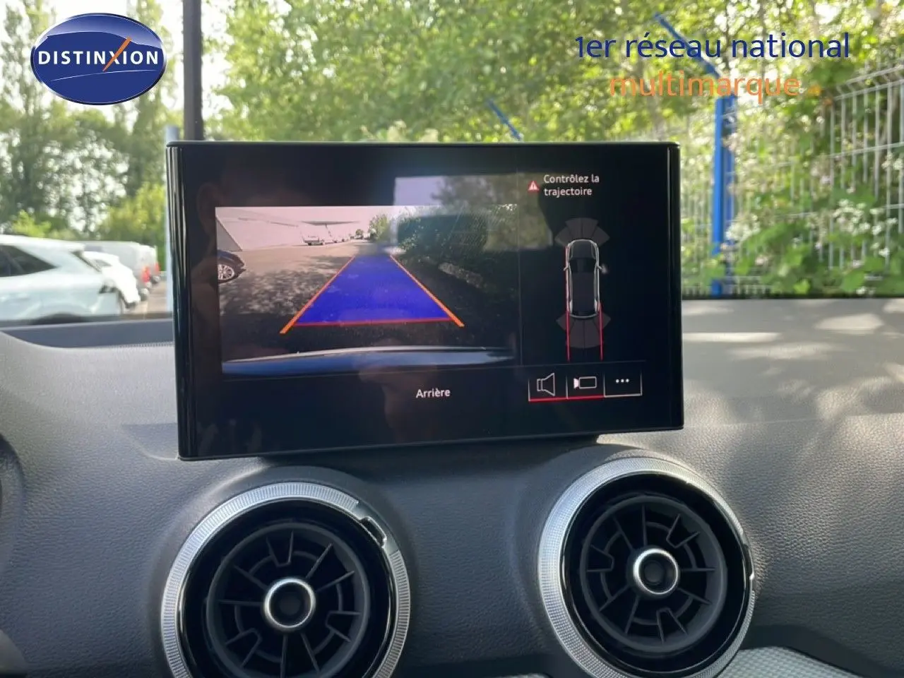 Écran central de l’Audi Q2 30 TDI S-Line 2025 montrant la caméra de recul avec guidage de trajectoire, intérieur gris.