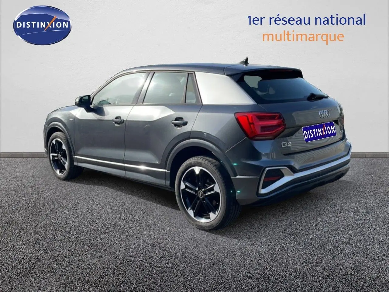 Audi Q2 30 TDI S-Line gris Manhattan métal, vue 3/4 arrière côté gauche, jantes noires distinctives.