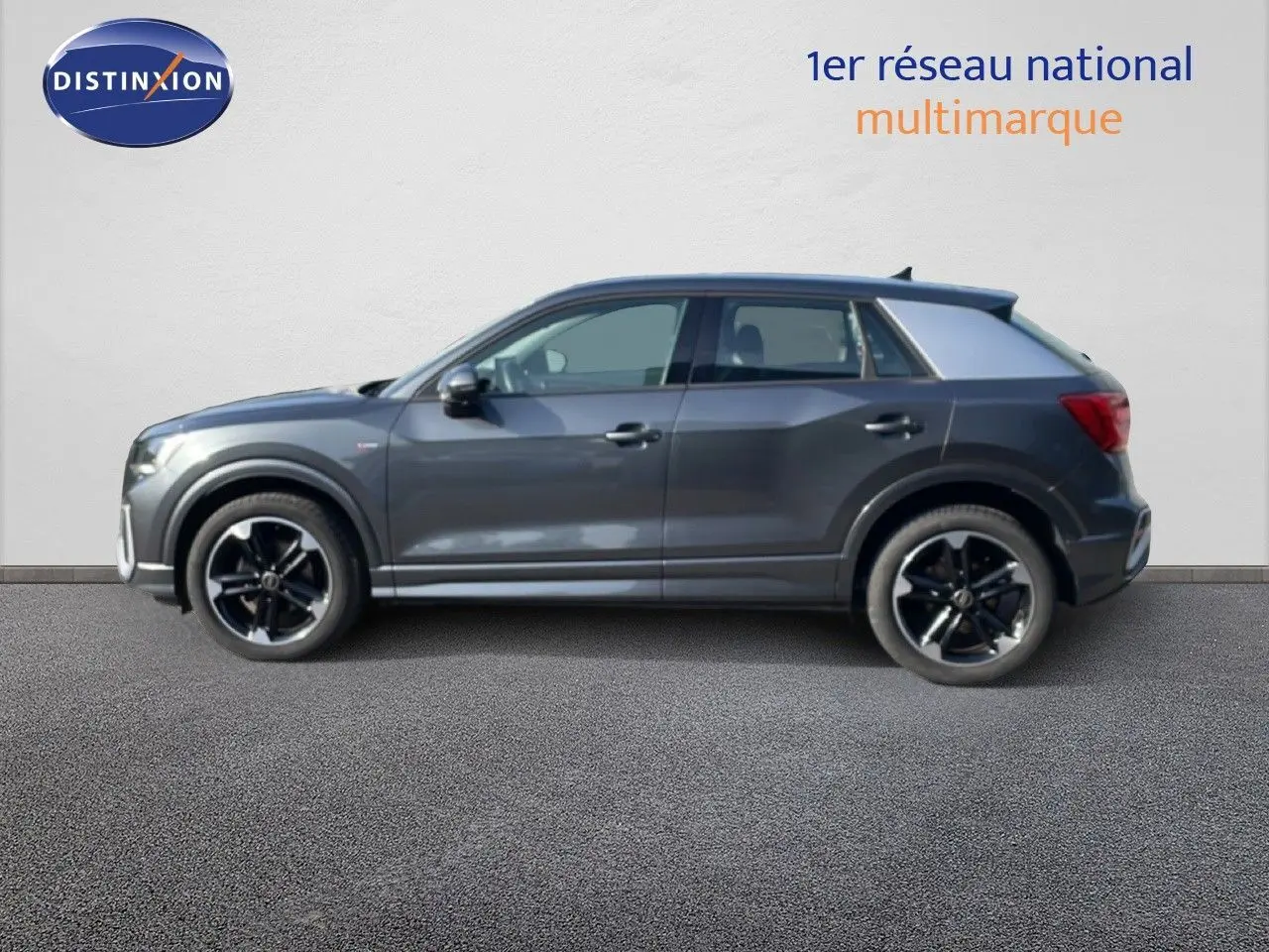Audi Q2 30 TDI S-Line gris Manhattan vu de profil côté gauche, avec jantes noires et détails sportifs visibles.
