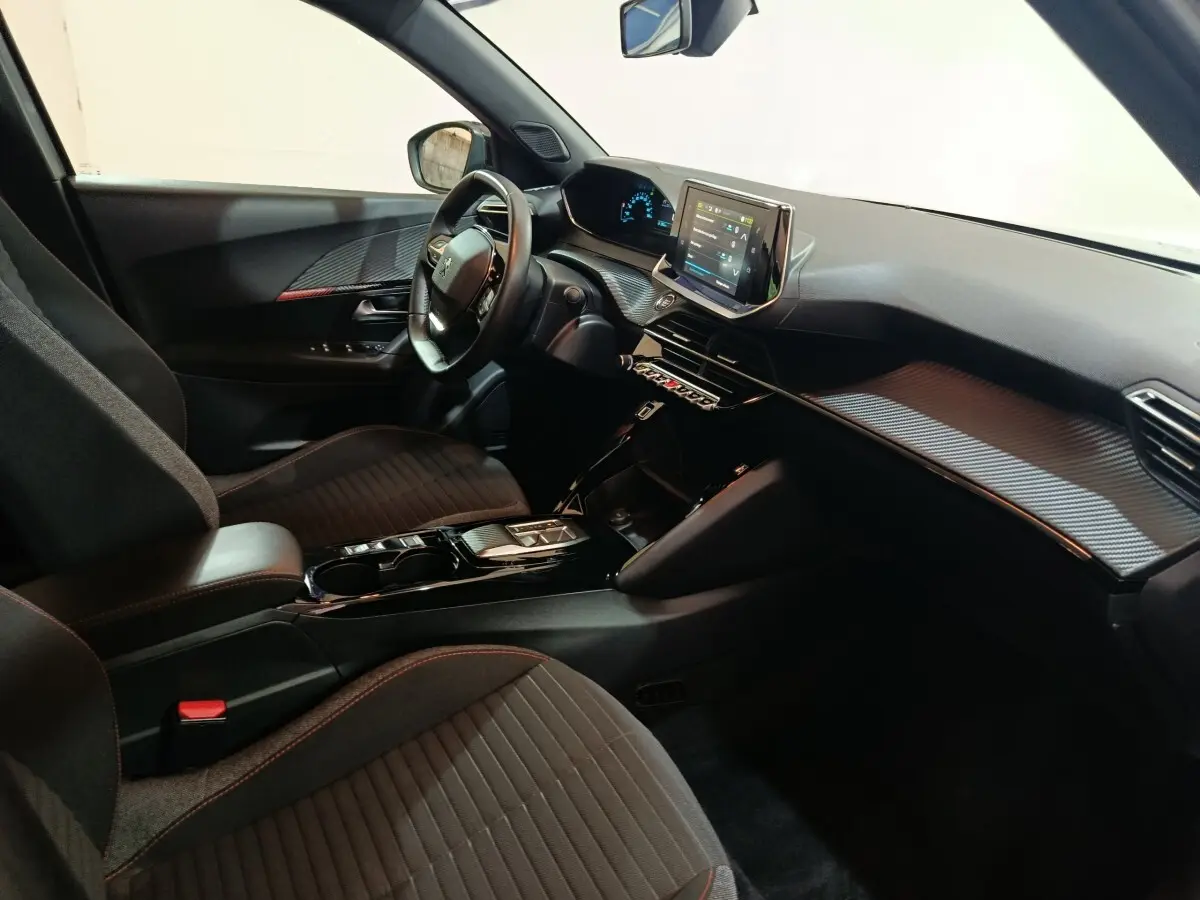 Intérieur côté conducteur du Peugeot E-2008 électrique gris clair 2023, avec tableau de bord digital et écran tactile central.