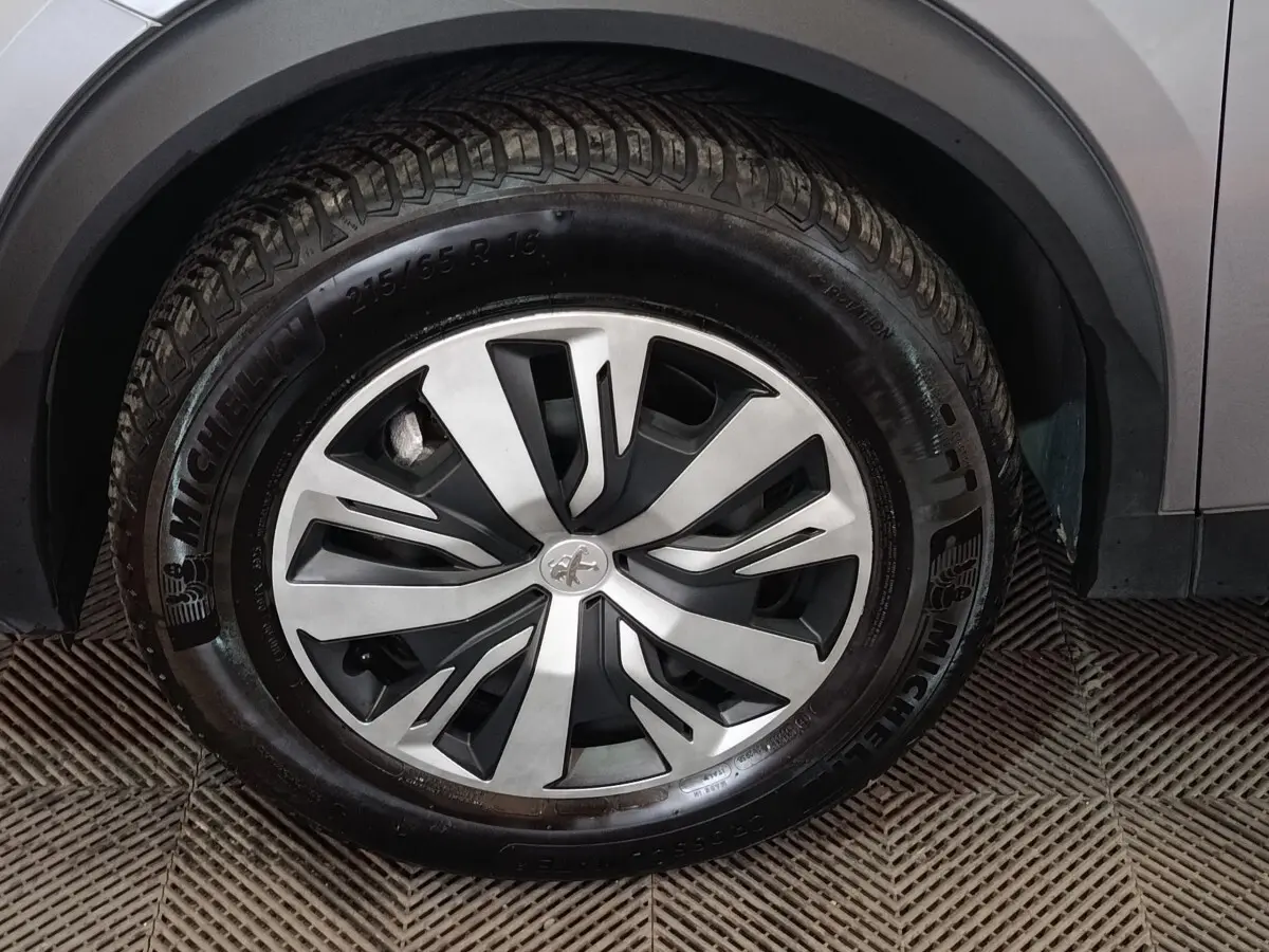Gros plan sur la roue avant droite gris clair du Peugeot E-2008 électrique avec jante alliage et pneu Michelin.