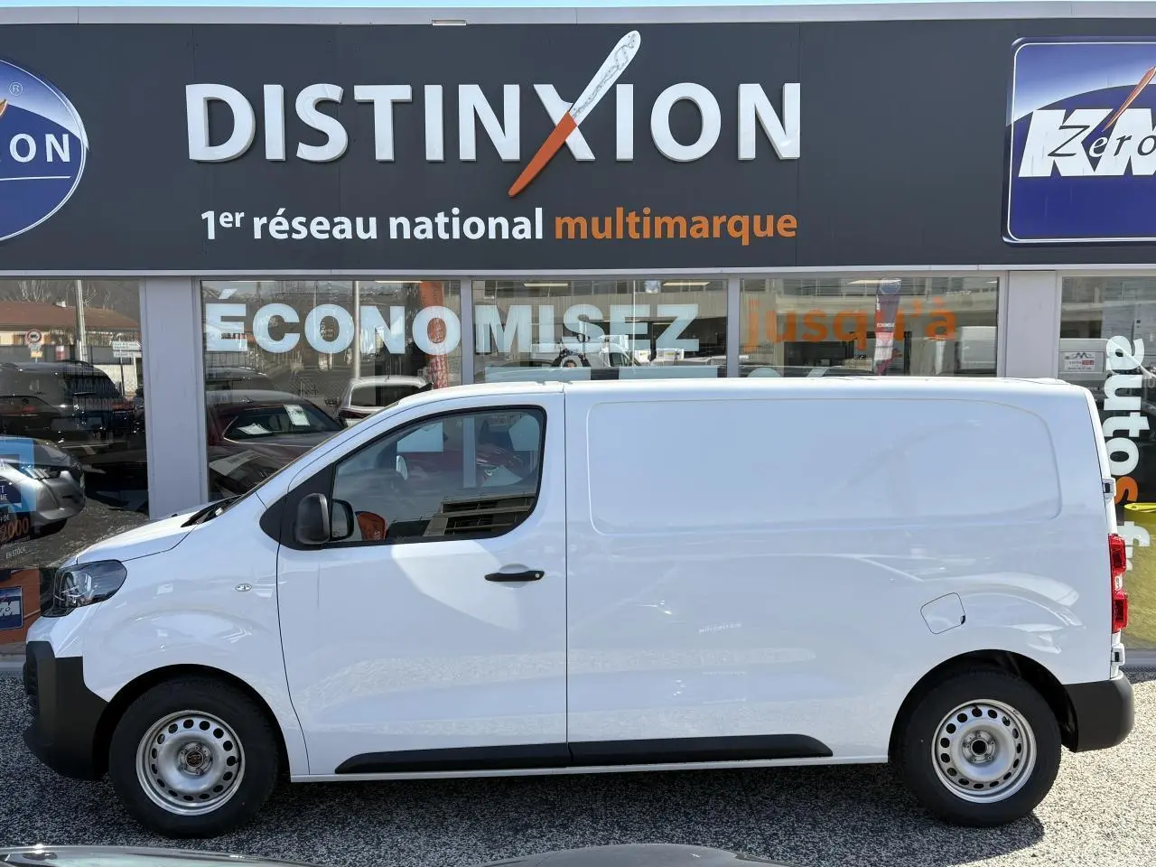 Opel Vivaro blanc vue de profil côté gauche, fourgon utilitaire avec porte coulissante et jantes acier simples.