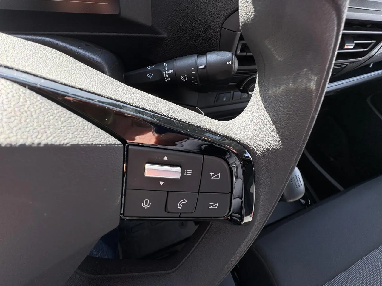 Gros plan sur les commandes au volant gris du poste de conduite de l'Opel Vivaro blanc 2024 avec boîte manuelle.