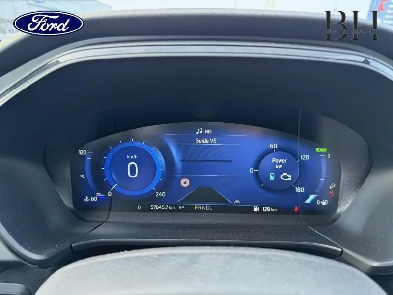 Tableau de bord numérique bleu du Ford Kuga 2023, affichant vitesse, puissance et informations de conduite.