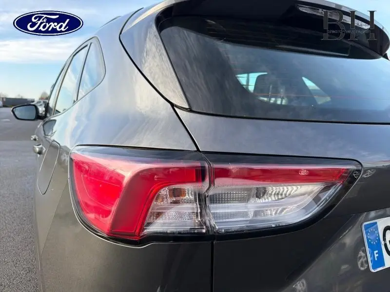 Vue arrière côté gauche du Ford Kuga 2023 gris Magnetic Métallisé avec feux arrière LED et hayon mains libres.