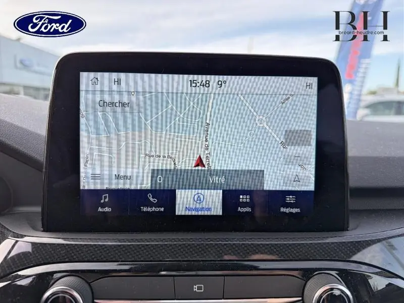 Écran tactile central du Ford Kuga 2023 affichant la navigation, vue intérieure avec tableau de bord noir.
